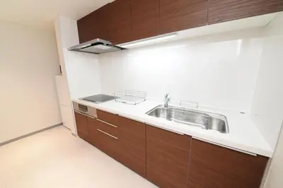 a kitchen with a sink and wooden cabinets at ACT one in Tokyo