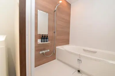 a bathroom with a shower with a white tub and a sink at ACT one in Tokyo