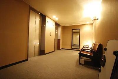 a hallway of a hotel room with a chair in it at Hotel Abest Meguro in Tokyo