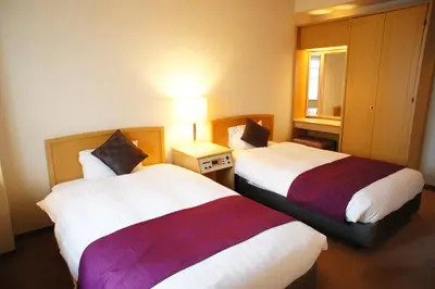 a hotel room with two beds and a lamp at Hotel Abest Meguro in Tokyo
