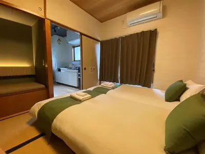 a bedroom with a large white bed with green pillows at Kagurazaka Retro BAR & HOTEL in Tokyo