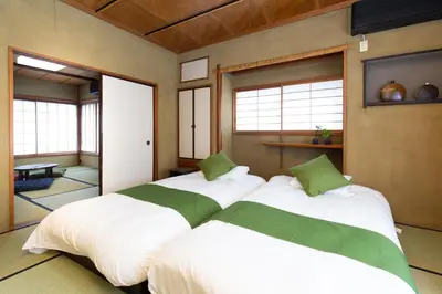 two large beds in a room with windows at Kagurazaka Retro BAR & HOTEL in Tokyo