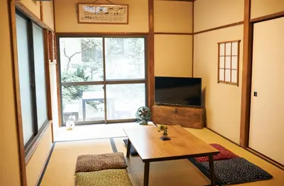 a living room with a table and a tv at Kagurazaka Retro BAR & HOTEL in Tokyo
