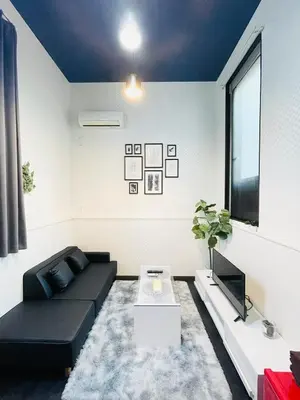 a living room with a black couch and a table at Alo BnB 4 - Near KABUKICHO, SHINJUKU, SHINOKUBO, SHIBUYA - Self check-in in Tokyo