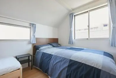 a bedroom with a bed and two windows at koiwa house 3LDK free wifi free parking in Tokyo