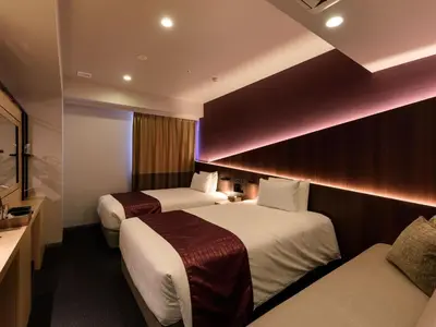 a hotel room with two beds and a television at Henn na Hotel Premier Tokyo Asakusa Tawaramachi in Tokyo