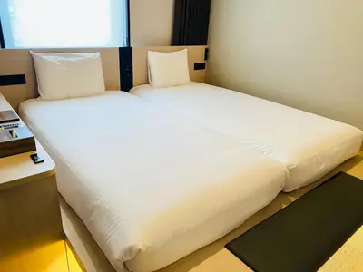 a large white bed in a small room at Henn na Hotel Premier Tokyo Asakusa Tawaramachi in Tokyo