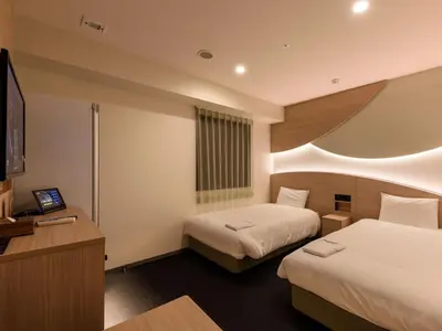 a hotel room with two beds and a flat screen tv at Henn na Hotel Premier Tokyo Asakusa Tawaramachi in Tokyo