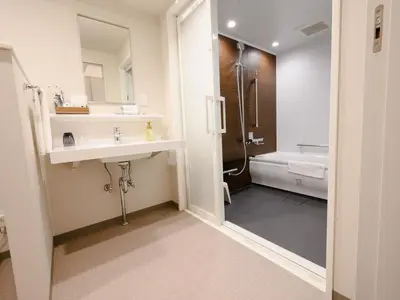 a bathroom with a sink and a shower and a toilet at Henn na Hotel Premier Tokyo Asakusa Tawaramachi in Tokyo
