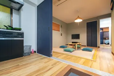 a living room with a table and a dining room at Skytree Tatami Hotel in Tokyo