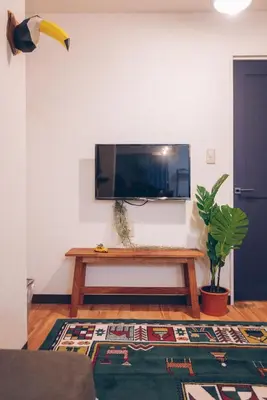 a living room with a tv and a wooden table at Skytree Tatami Hotel in Tokyo
