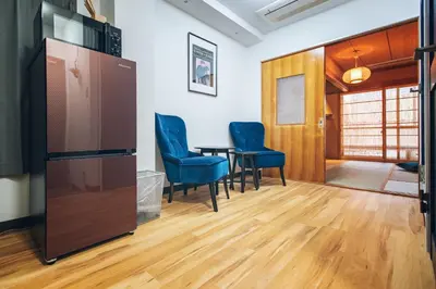 a room with a table and chairs and a refrigerator at Skytree Tatami Hotel in Tokyo