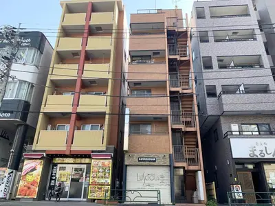 a tall apartment building with shops in front of it at Skytree Tatami Hotel in Tokyo
