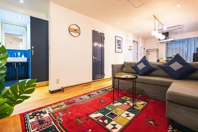 a living room with a couch and a rug at Skytree Tatami Hotel in Tokyo