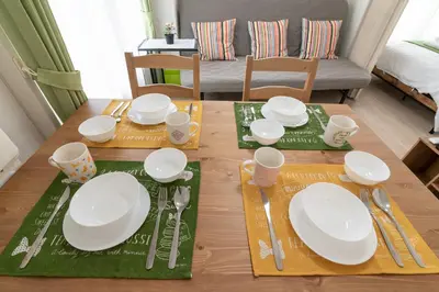 a dining room table with white plates and utensils at Uhome Iriya Apartment in Tokyo