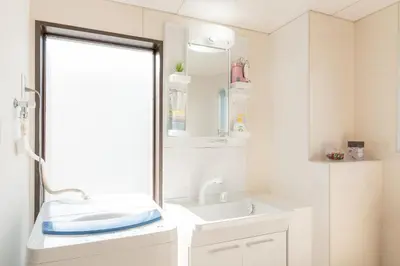 a bathroom with a sink and a mirror at Uhome Iriya Apartment in Tokyo