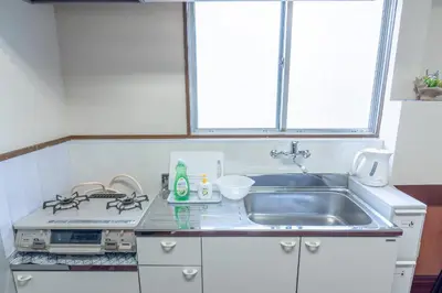 a kitchen with a sink and a stove and a window at Uhome Iriya Apartment in Tokyo