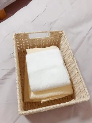 a basket filled with white towels on a bed at C.H.House in Tokyo
