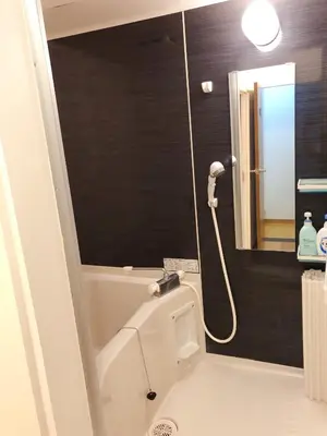 a bathroom with a bath tub and a mirror at C.H.House in Tokyo