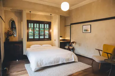 a bedroom with a large white bed and a window at Guesthouse toco in Tokyo