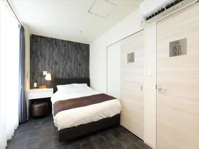 a bedroom with a bed and a sliding door at CHA-AN HOTEL UENO in Tokyo