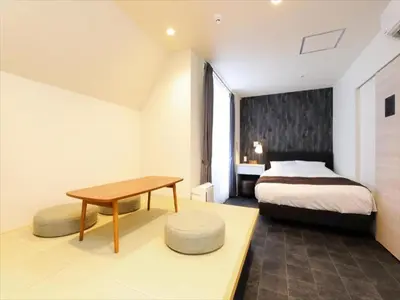 a bedroom with a bed and a table and a desk at CHA-AN HOTEL UENO in Tokyo
