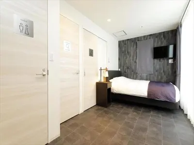 a bedroom with a bed and a sliding door at CHA-AN HOTEL UENO in Tokyo