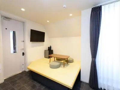a room with a desk and a table and a window at CHA-AN HOTEL UENO in Tokyo