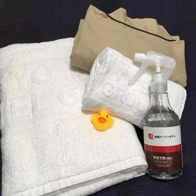 a pile of towels and a bottle of mouthwash and a rubber duck soap at Shinbashi Urban Hotel in Tokyo