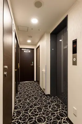 a corridor of a hotel hallway with a carpeted floor at Shinbashi Urban Hotel in Tokyo