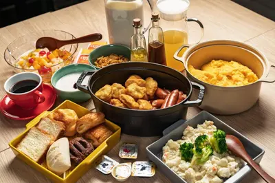 a table with a buffet of food on a table at Grids Tokyo Ueno Hotel&Hostel in Tokyo