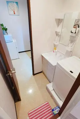 a bathroom with a sink and a washing machine at Mitsuba Guest House in Tokyo
