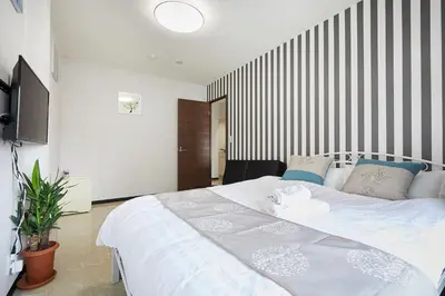 a bedroom with a large white bed in a room at Mitsuba Guest House in Tokyo