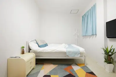 a small bedroom with a bed and a tv at Mitsuba Guest House in Tokyo