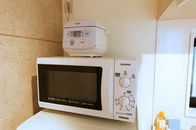 a microwave oven sitting on top of a counter at nestay house tokyo itabashi 01 in Tokyo