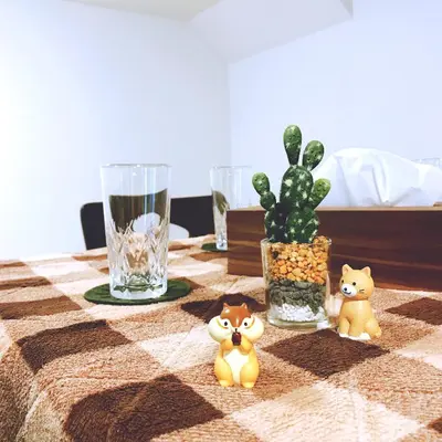 a table with a cat figurines on a checkered table cloth at nestay house tokyo itabashi 01 in Tokyo
