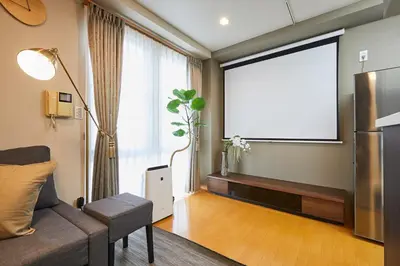 a living room with a couch and a projection screen at 22-Sweet Dreams House in JR Okubo Station 5 min in Tokyo