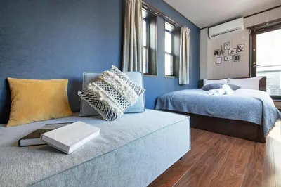 a blue room with two beds and a couch at Calm Asakusa Kaminarimon Gate CLx in Tokyo