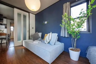 a blue living room with a couch and a plant at Calm Asakusa Kaminarimon Gate CLx in Tokyo