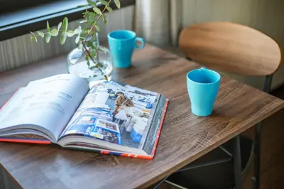 an open book on a wooden table with blue cups at Calm Asakusa Kaminarimon Gate CLx in Tokyo