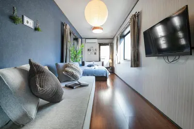 a living room with a couch and a tv at Calm Asakusa Kaminarimon Gate CLx in Tokyo