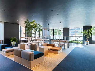 a lobby with couches and tables and windows at Mitsui Garden Hotel Jingugaien Tokyo Premier in Tokyo