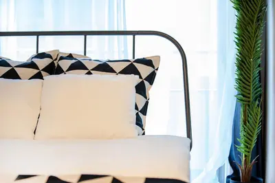 a black and white couch with pillows in front of a window at Tokyo Sunshine Tower Premium Hotel in Tokyo