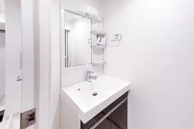 a white bathroom with a sink and a mirror at Tokyo Sunshine Tower Premium Hotel in Tokyo
