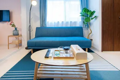 a living room with a blue couch and a table at Tokyo Sunshine Tower Premium Hotel in Tokyo