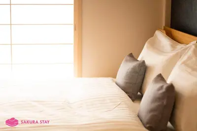 a bedroom with a bed with pillows and a window at Sakura Stay Yoga 201 in Tokyo