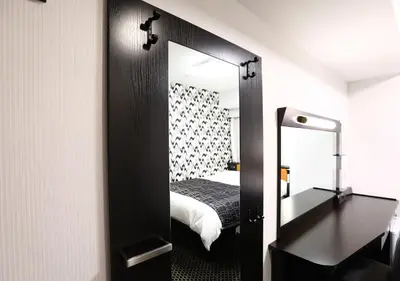 a bedroom with a mirror and a bed in a room at APA Hotel Ayase Ekimae in Tokyo