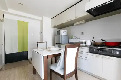 a kitchen with a table and chairs in a room at G-Shinkoiwa ColorBee Hostel4 4min to nearest station in Tokyo