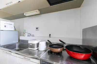 a kitchen counter with two pots and pans on the stove at G-Shinkoiwa ColorBee Hostel4 4min to nearest station in Tokyo