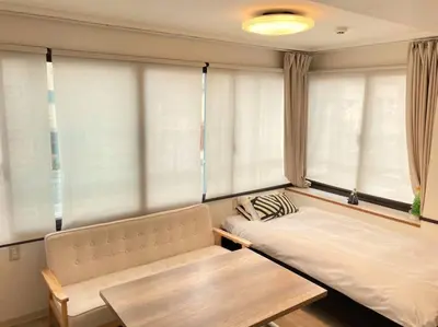 a room with a couch and a table and windows at KEYHOTEL-5minutes for walk to Akihabara Electric Town in Tokyo